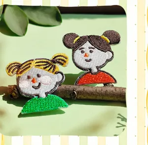 Gros plan sur les ecussons brodes de filles mignonnes, coutures detaillees et motifs colores.