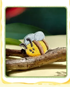 Detailed close-up of cute embroidered bee patch showcasing fine stitching and vibrant colors.