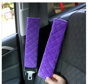 Close-up view of purple plush car seat belt shoulder pad showing soft diamond texture.