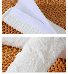 Detailed view of white puff car seat belt shoulder pad surface texture and velcro closure.