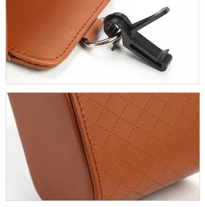 Car storage box detail showing durable brown leather, quilted pattern and sturdy vent clip.