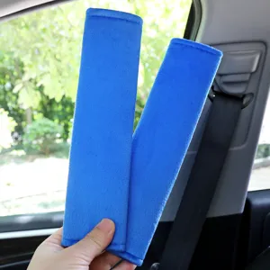 Soft blue plush car seat belt shoulder pads detail shot, comfortable anti chafing cover.