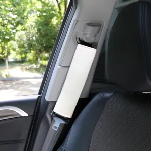 Detailed view of soft beige car seatbelt shoulder pad installed, comfortable driving accessory.