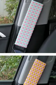 Detailed view of colorful checkered car seatbelt shoulder pad, interior decor item.