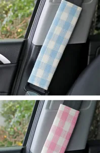 Soft plaid fabric car seatbelt shoulder pad detail view, comfortable anti-wear interior accessory.