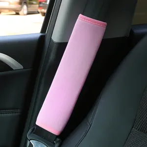 Soft pink car seat belt shoulder pad protective cover, comfortable fabric cushion for driving.