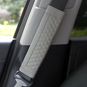Grey leather car seatbelt shoulder pad with stylish diamond quilting for comfortable driving.