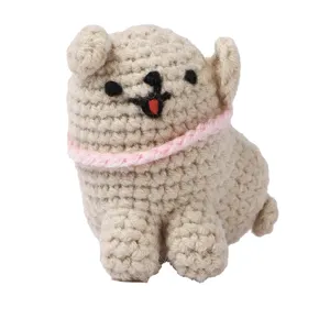 Gedetailleerde close-up van de schattige handgemaakte gehaakte beige puppy pop met roze halsband.