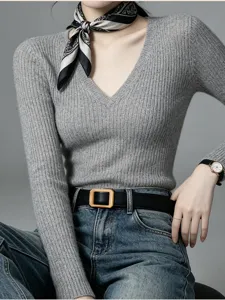 Close-up detail view of women's stylish ribbed V-neck sweater and leather belt outfit.