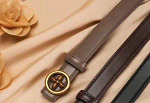 Close-up detail of women's genuine leather belt with metallic flower buckle and smooth finish.