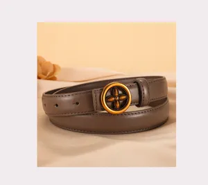 Brown leather belt detail showing the golden circular four-petal flower buckle design.