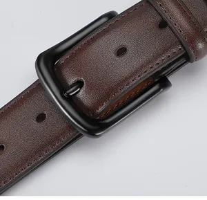 Close up view of men leather belt matte black pin buckle and brown textured cowhide strap detail.