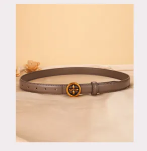 Close-up detail of stylish women's genuine leather belt with metallic flower buckle design.