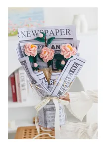 Handgemachte Häkel-Kamelien-Blumenstrauß, exquisite Strickdetails und stilvolle Retro-Zeitungspapier.