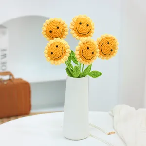 Handgemachter Häkel-Sonnenblumenstrauß mit niedlichem lächelndem Gesicht im weißen Vasendekor.