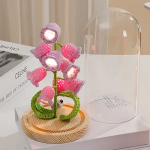 Handmade crochet lily of the valley night light with glass dome and wooden base for home decor gift.