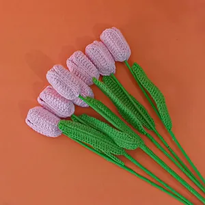 Handmade crochet tulip flower detail showing fine pink wool petals and clean green stems.