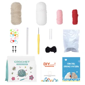 Haakset voor beginners met garenrollen, haaknaald, vulling en koeienpop patroon instructies.