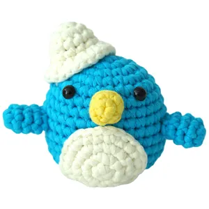 Poupée pingouin bleue au crochet faite à la main avec chapeau blanc et bec jaune.