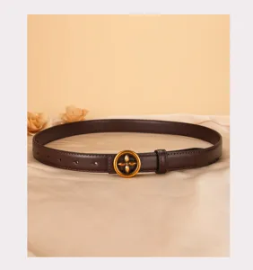 Close-up detail of women's brown leather belt featuring a vintage gold flower buckle.