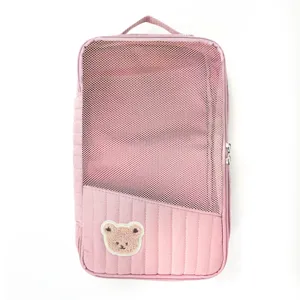 Pink travel storage bag with mesh top and cute bear patch, portable packing organizer.