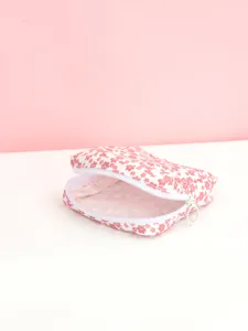 Détail de pochette de rangement en tissu à fleurs roses, vue de porte-monnaie zippé compact.