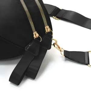 Black nylon crossbody bag for women, stylish chest bag with dual gold zippers and wide strap.