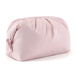 Close-up detail of the soft pink cloud cosmetic bag zipper and pleated fabric texture.