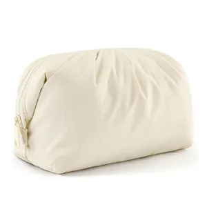 Close-up detail of the cream white cosmetic pouch, showing the soft cloud pleated fabric texture.