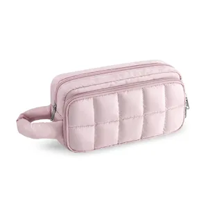 Quilted makeup bag detail showing soft pink fabric, sturdy handle, and smooth double zippers.