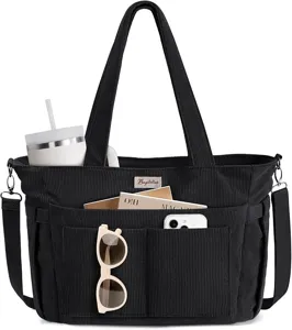 Close-up detail of the black corduroy tote bag featuring multi-functional front pockets.