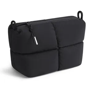 Black quilted cosmetic pouch detail, minimalist puff makeup bag, soft clutch zipper bag.