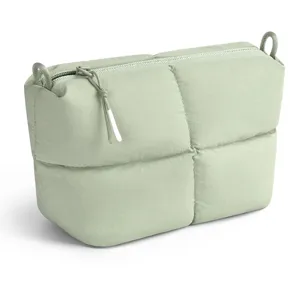 Close-up detail of the sage green quilted cosmetic bag with zipper and stitching design.