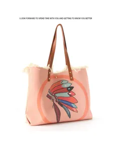 Canvas tote bag detailed view showcasing boho feather print and brown leather handles.
