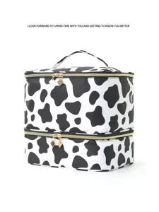 Dettaglio borsa cosmetica a doppio strato con stampa mucca, borsone da toilette con zip dorate.