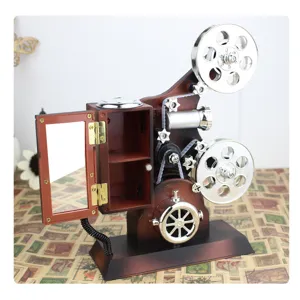 Retro film projector music box detail showing exquisite gears, reels and open mirror cabinet.