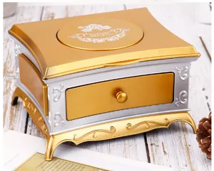 Retro vintage music box detail view, elegant gold and silver jewelry storage with drawer.