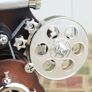 Vintage projector music box main view, featuring a shiny silver film reel close-up.
