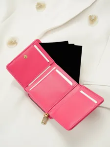 Close-up detail of pink trifold wallet interior, featuring card slots and zipper coin pocket.