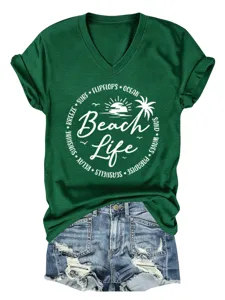 Detail view of dark green V-neck short sleeve tee with beach life graphic and denim shorts.