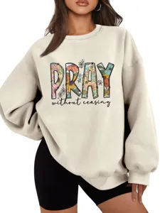 Primo piano della felpa beige elegante con stampa floreale grafica PRAY sul petto.