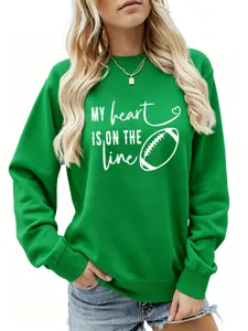 Primo piano della felpa verde con una grafica da football bianco e un testo stimolante.