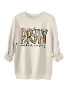 Dettaglio ravvicinato del testo stampato con motivo floreale PRAY sulla comoda felpa beige.