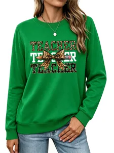 Detalle de cerca de la sudadera verde de maestra con estampado de lazo de leopardo y lápiz.