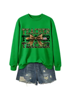 Primer plano de la sudadera verde con gráfico de texto de profesor leopardo y lazo de lápiz.
