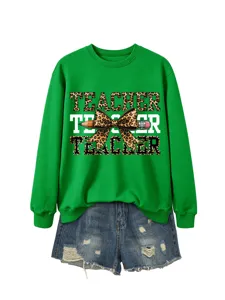 Detalle de sudadera de profesor verde con estampado gráfico de lazo de leopardo y lápiz.