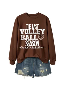 Detailansicht eines braunen langärmligen Sweatshirts mit weißem Volleyball-Textdruck und Jeans.