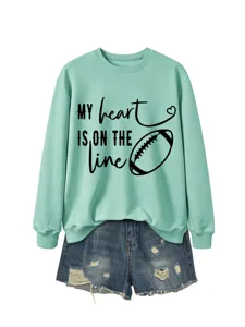 Felpa girocollo verde menta con grafica da football e testo motivazionale, abbinata ai jeans.