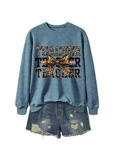 Primer plano de la sudadera azul con texto de profesor de leopardo y detalle de lazo.