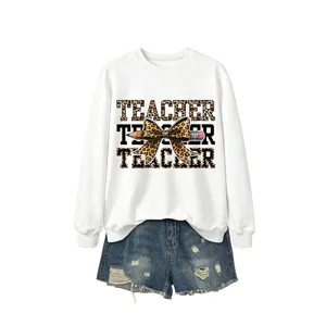 Sudadera blanca de manga larga para mujer con estampado de leopardo y shorts vaqueros.